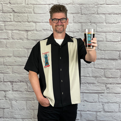 This loose, comfortable, and airy "Kahiki Tiki Supper Club" PopCheck Double Panel Bowling Shirt in Black/Stone is great for all you tiki lovers out there! It features the infamous tiki from the The Kahiki Supper Club, embroidered on a single stone panel of the black polyester shirt and features custom metal tiki buttons! 
